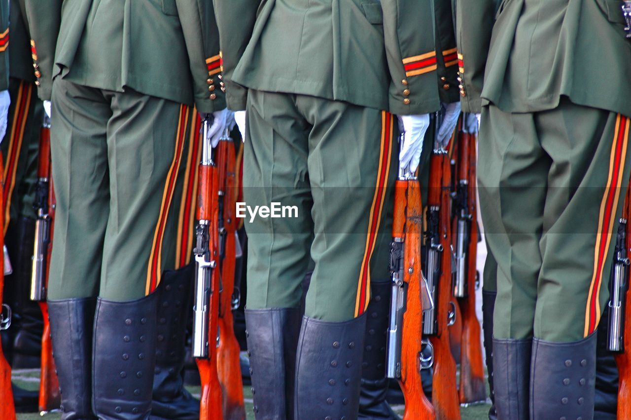 Midsection of soldiers standing side by side
