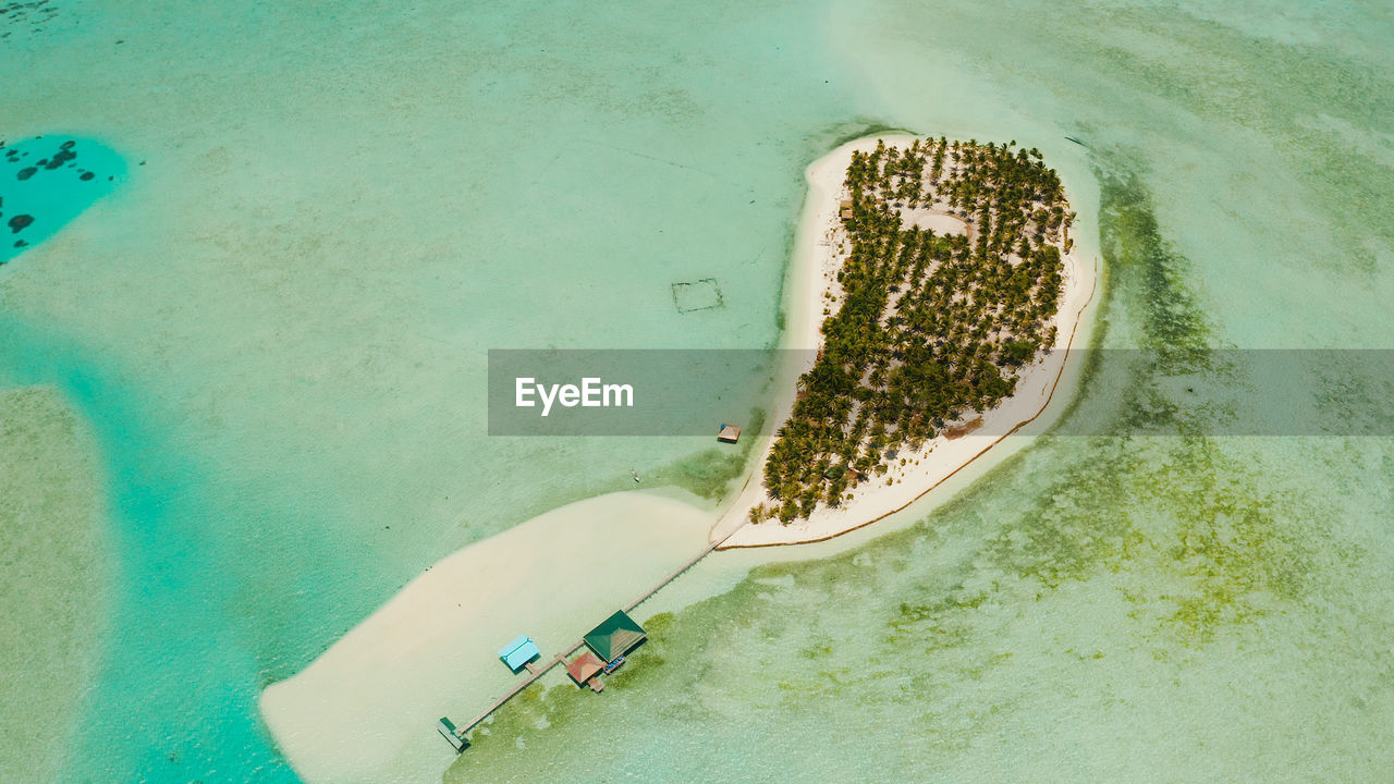 Small island with beautiful beach, palm trees by turquoise water. onok island, balabac