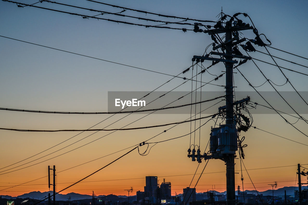 low angle view of electricity pylon against sky during sunset