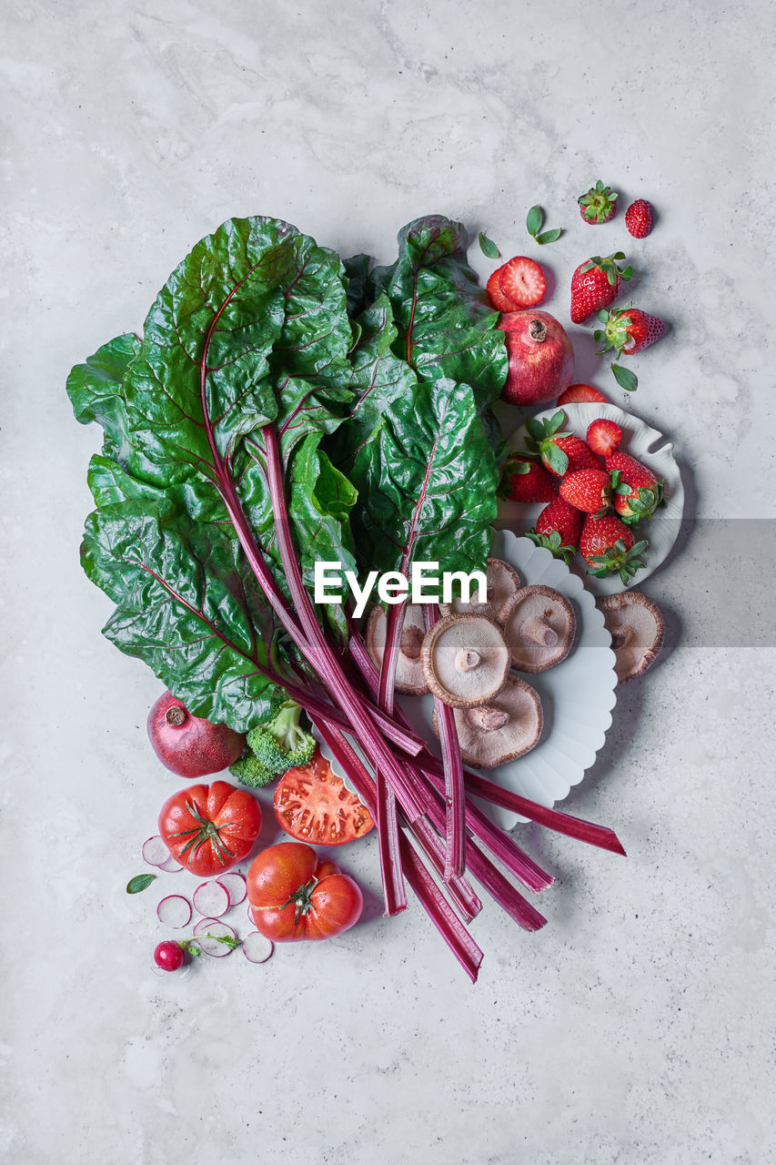 Top view of different fresh vegetables and fruit on a white table