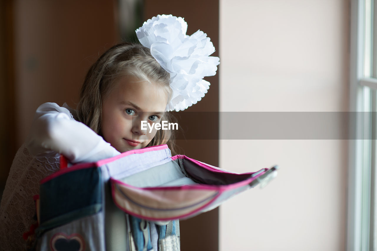 Portrait of cute girl packing bag at home