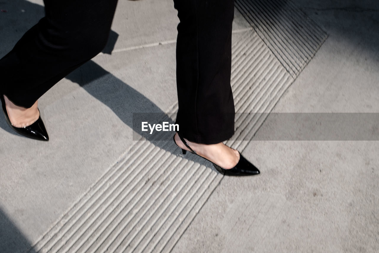 Low section of woman walking on street