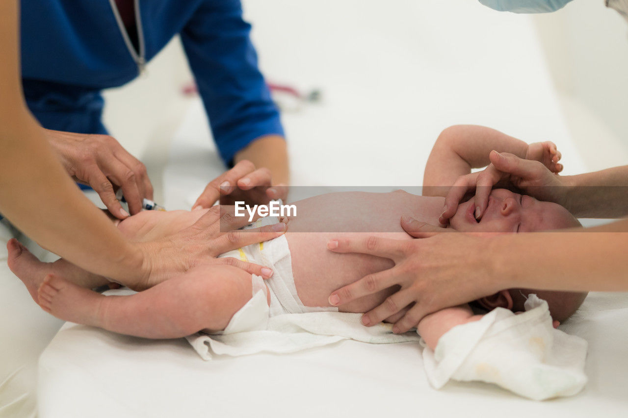 midsection of doctor examining patient on bed