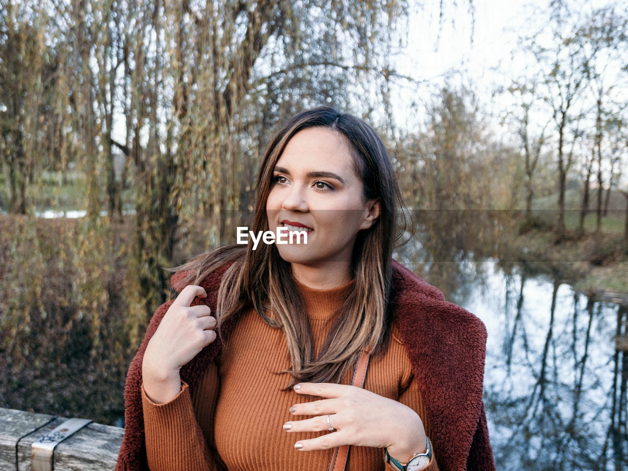 Portrait of happy young woman in winter clothes in park.