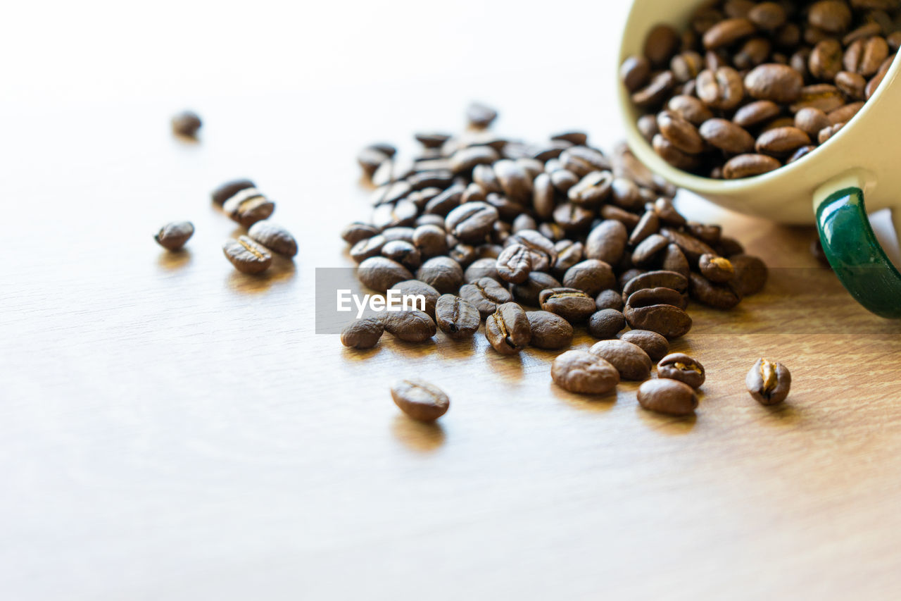 HIGH ANGLE VIEW OF COFFEE BEANS IN GLASS ON TABLE