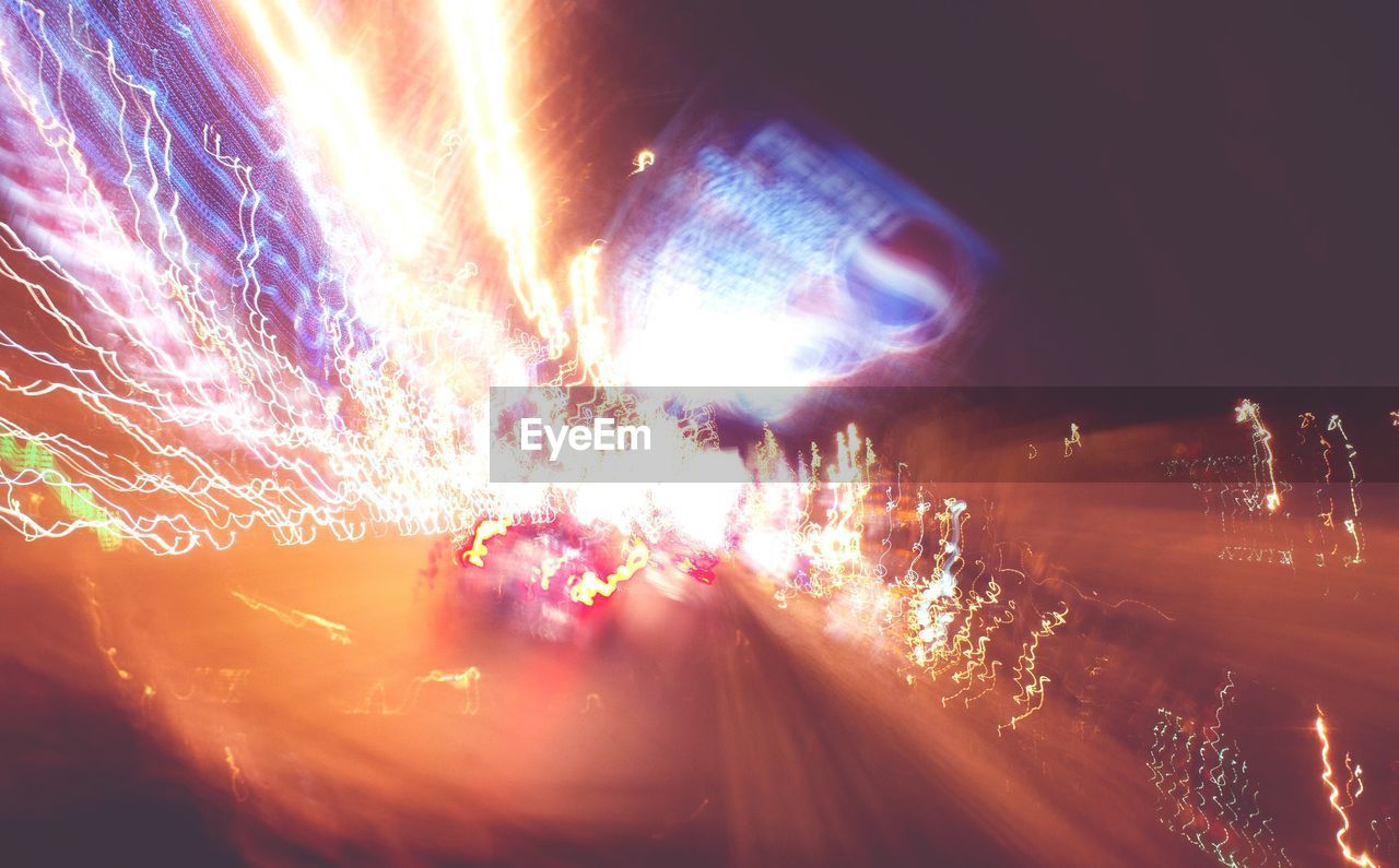 BLURRED MOTION OF ILLUMINATED FIREWORKS AT NIGHT