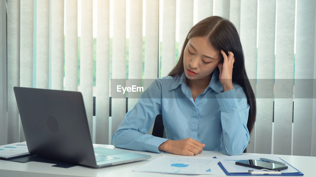 Businesswoman looking at graph in office