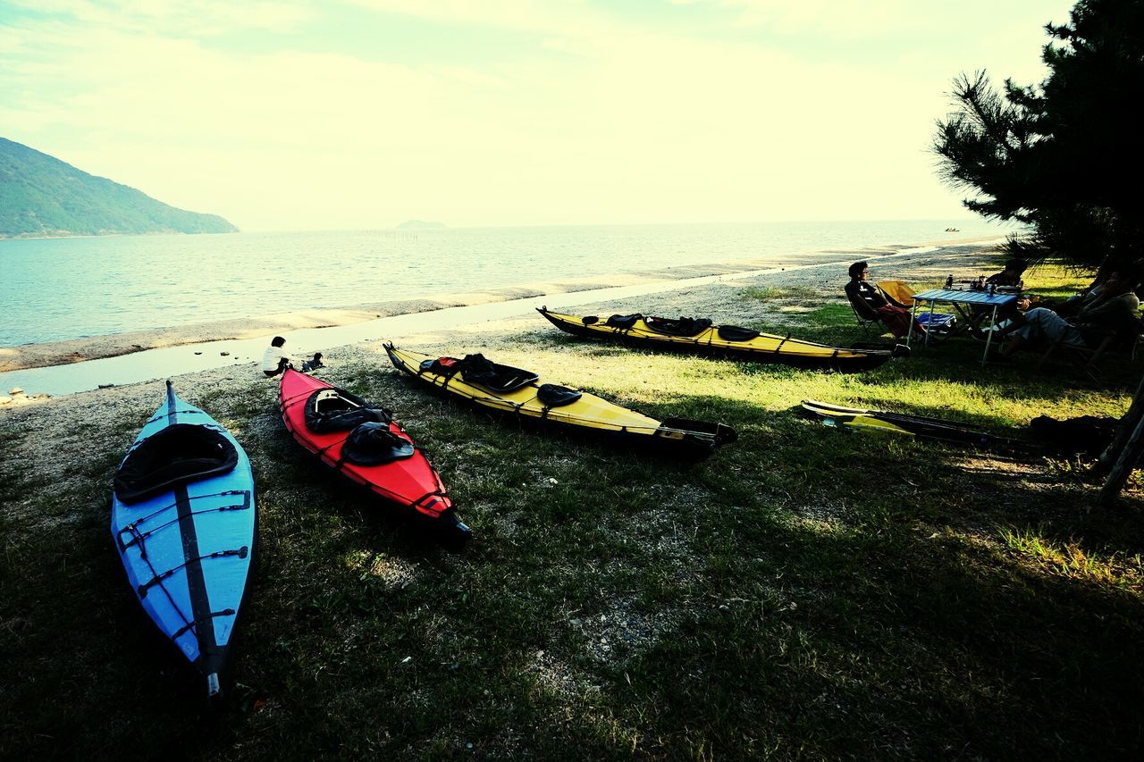 Kayaks moored on shore against sky