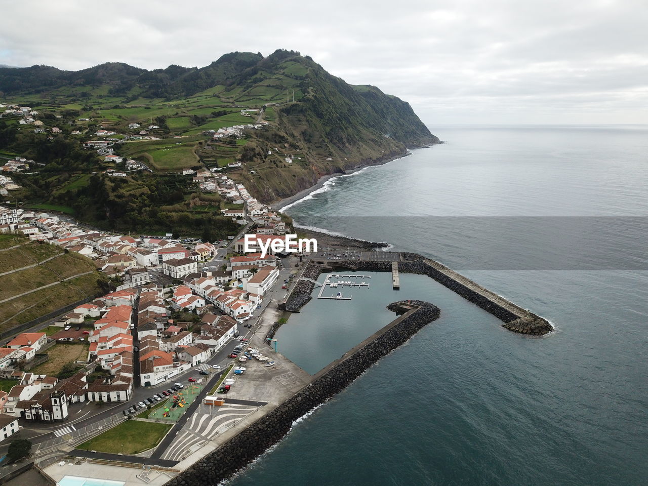High angle view of townscape by sea against sky
