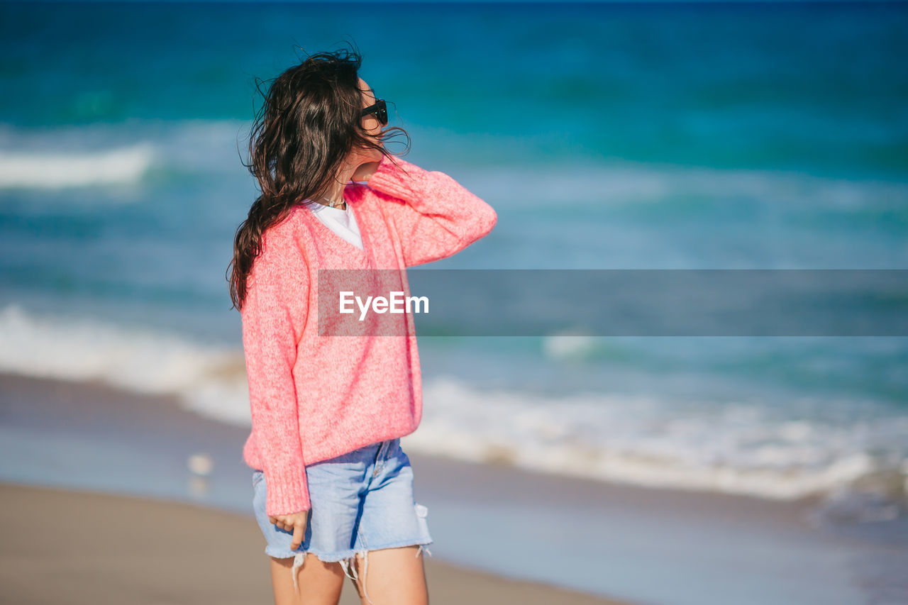 side view of woman standing at beach