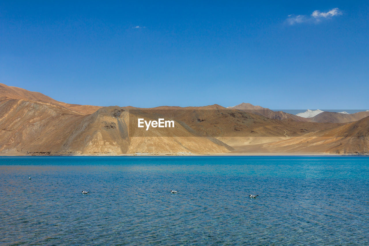 Scenic view of sea and mountains against sky