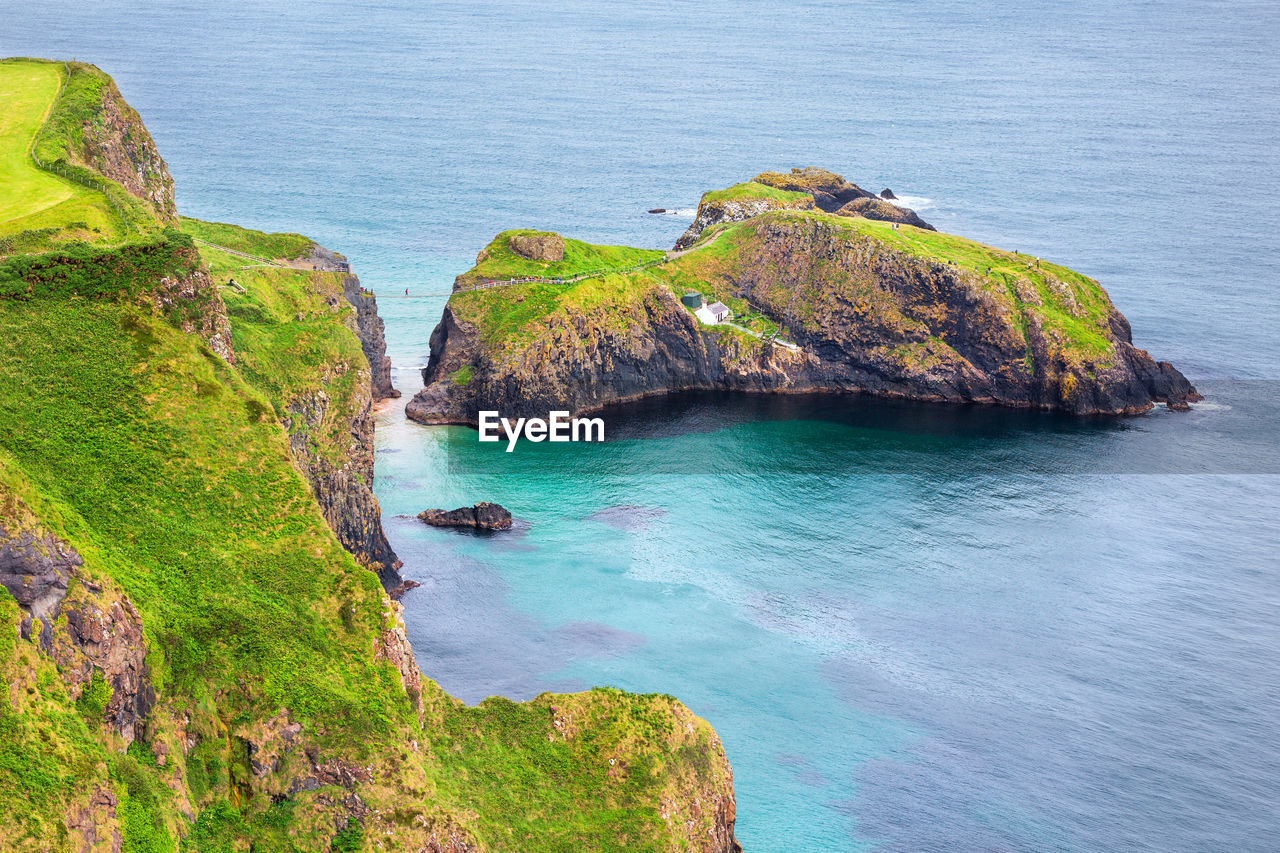 HIGH ANGLE VIEW OF ROCK FORMATION ON SEA