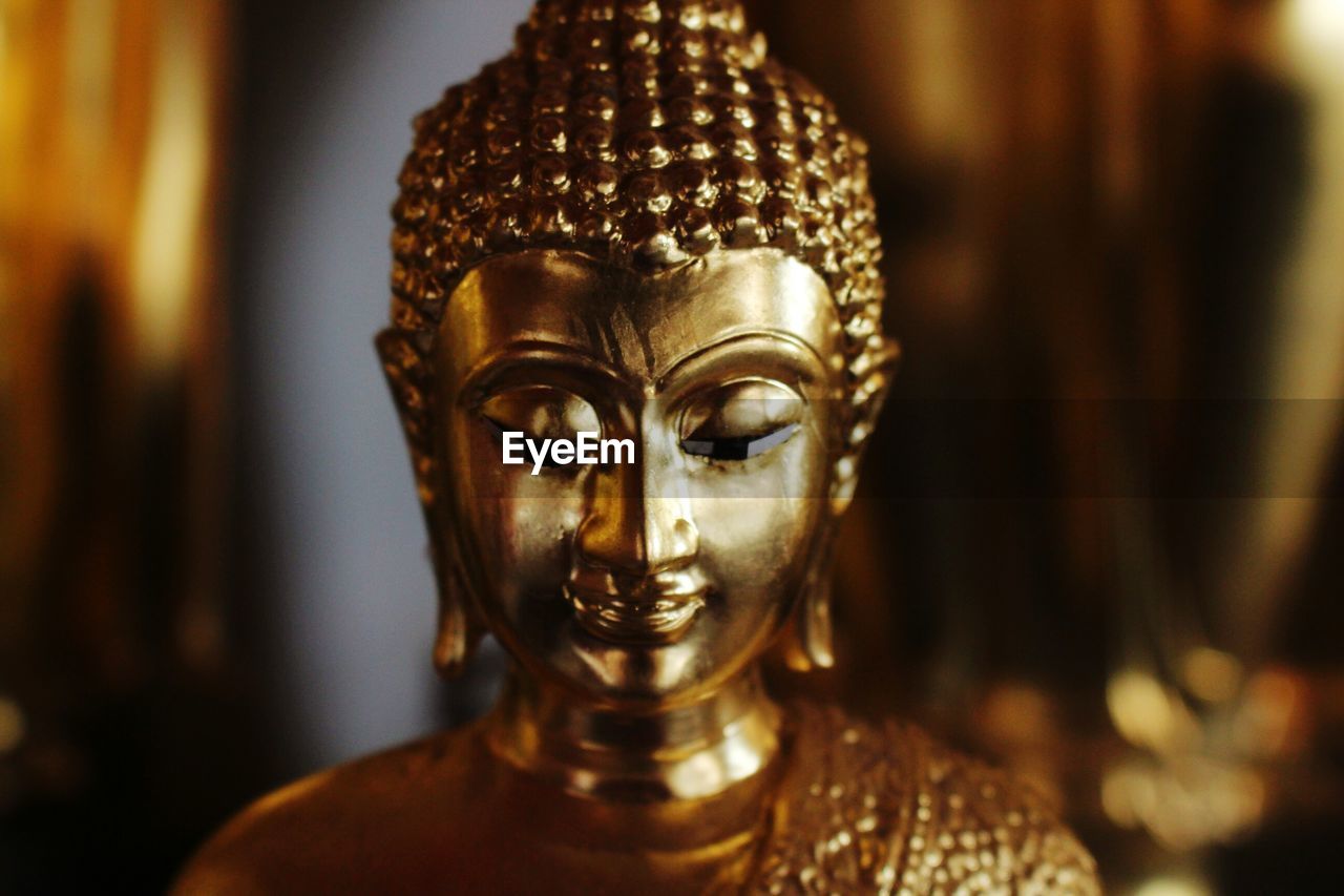 Close-up of gold buddha statue in temple