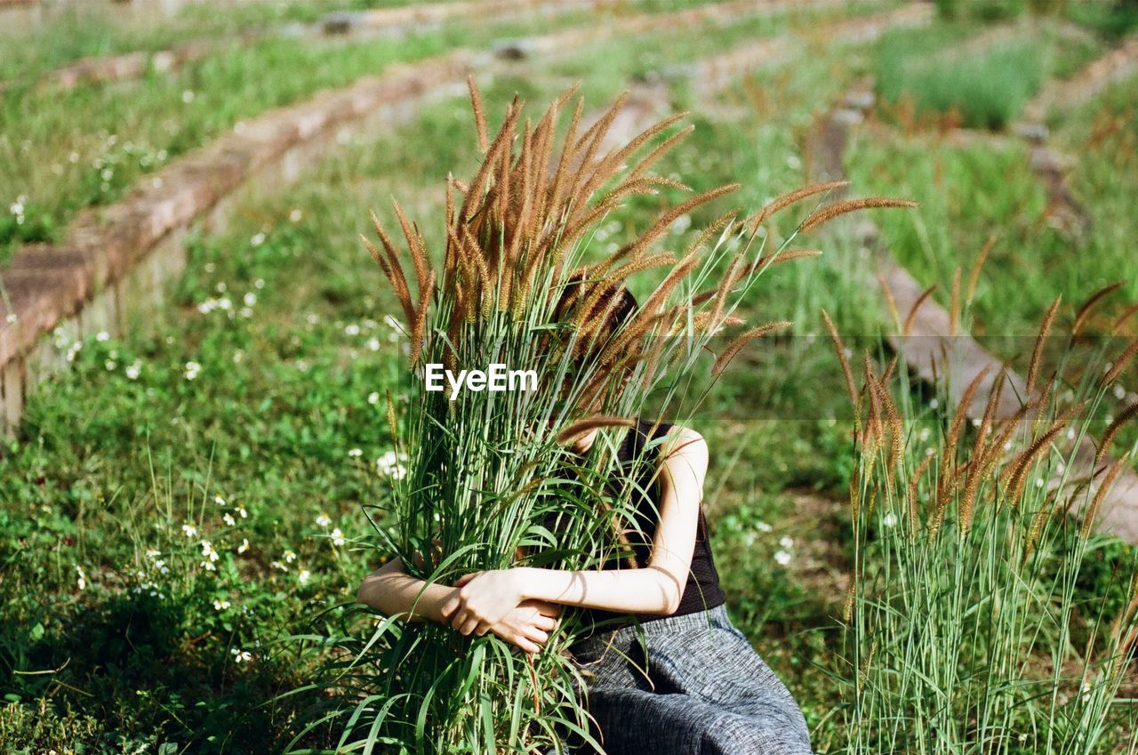 Woman hugging grass on field