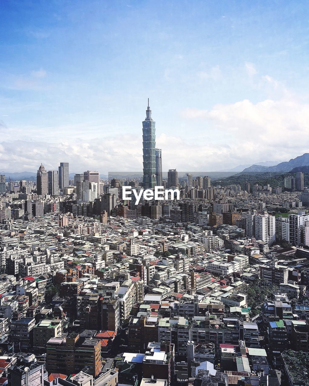 Aerial view of city buildings against cloudy sky