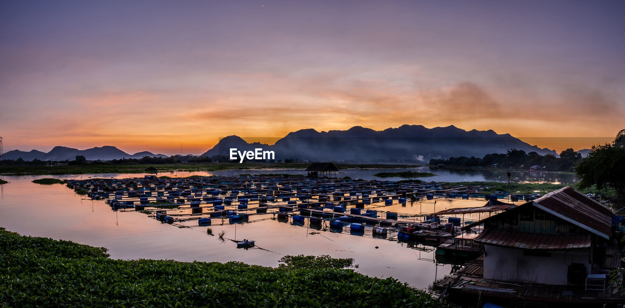 High angle view of buildings by sea against sky during sunset