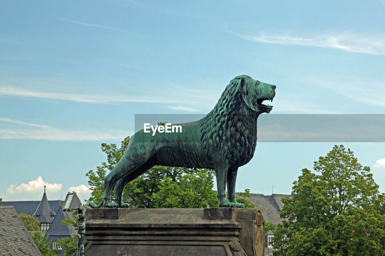 LOW ANGLE VIEW OF STATUE AGAINST BLUE SKY