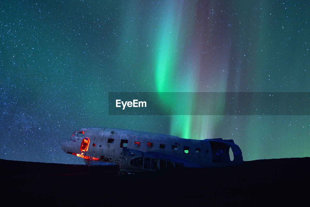 Northern lights over plane wreckage in iceland.old crashed military plane in solheimasandur 