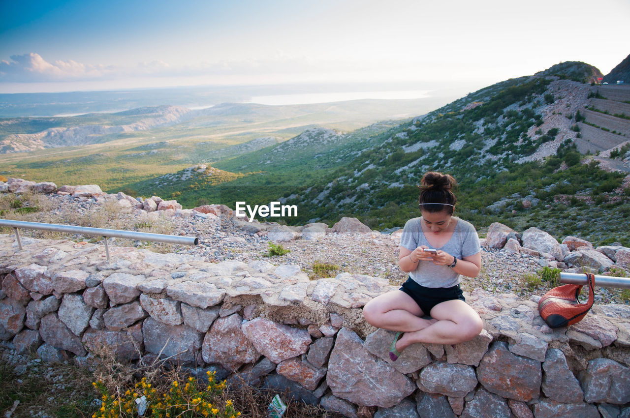 WOMAN SITTING ON MOUNTAIN