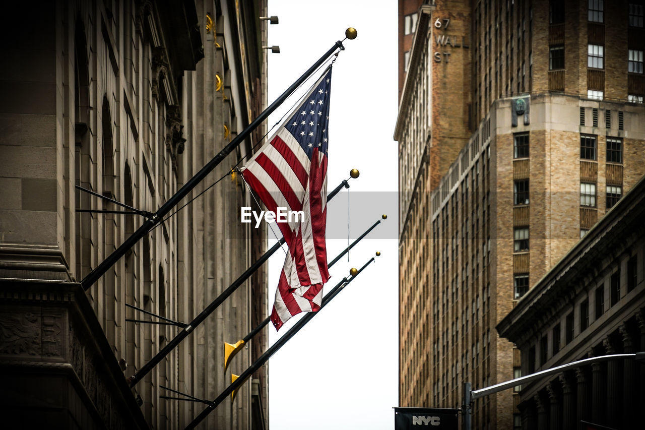 LOW ANGLE VIEW OF FLAGS ON BUILDINGS IN CITY