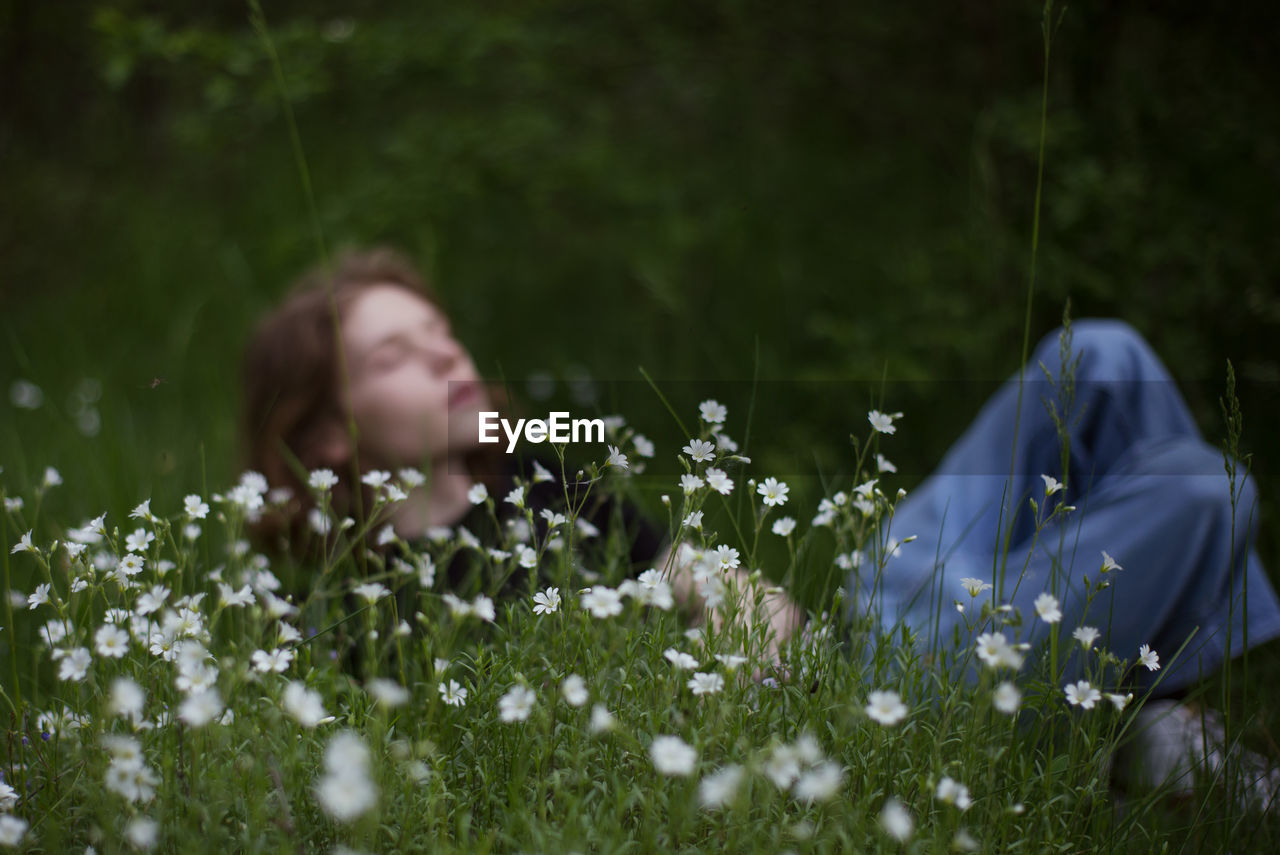 REAR VIEW OF WOMAN ON FLOWERING FIELD