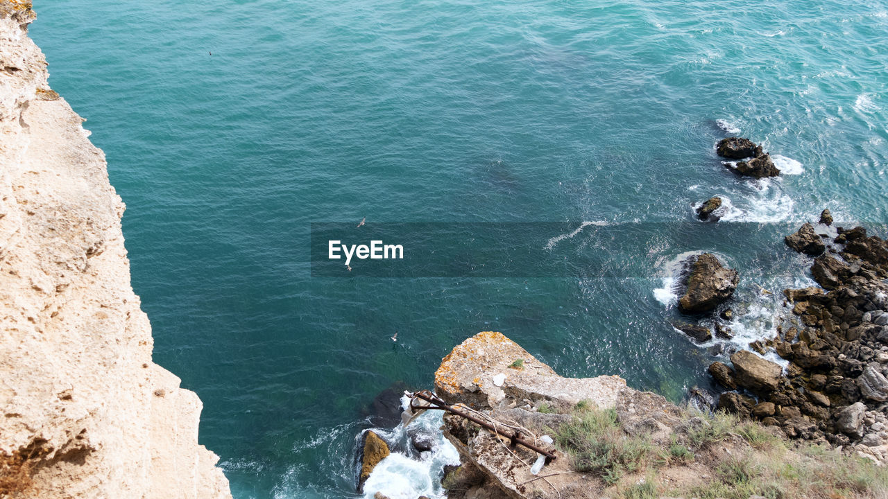 High angle view of rocks on sea shore