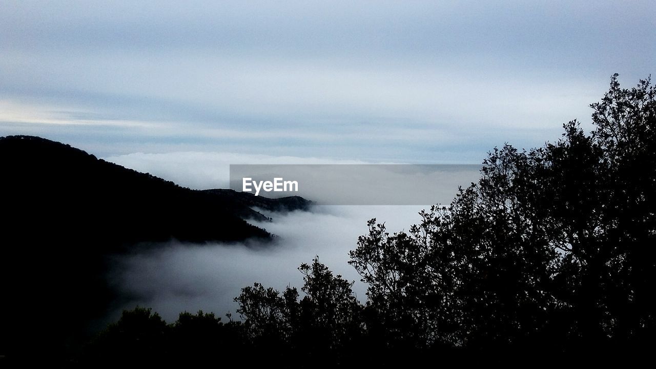 Scenic view of mountains against cloudy sky