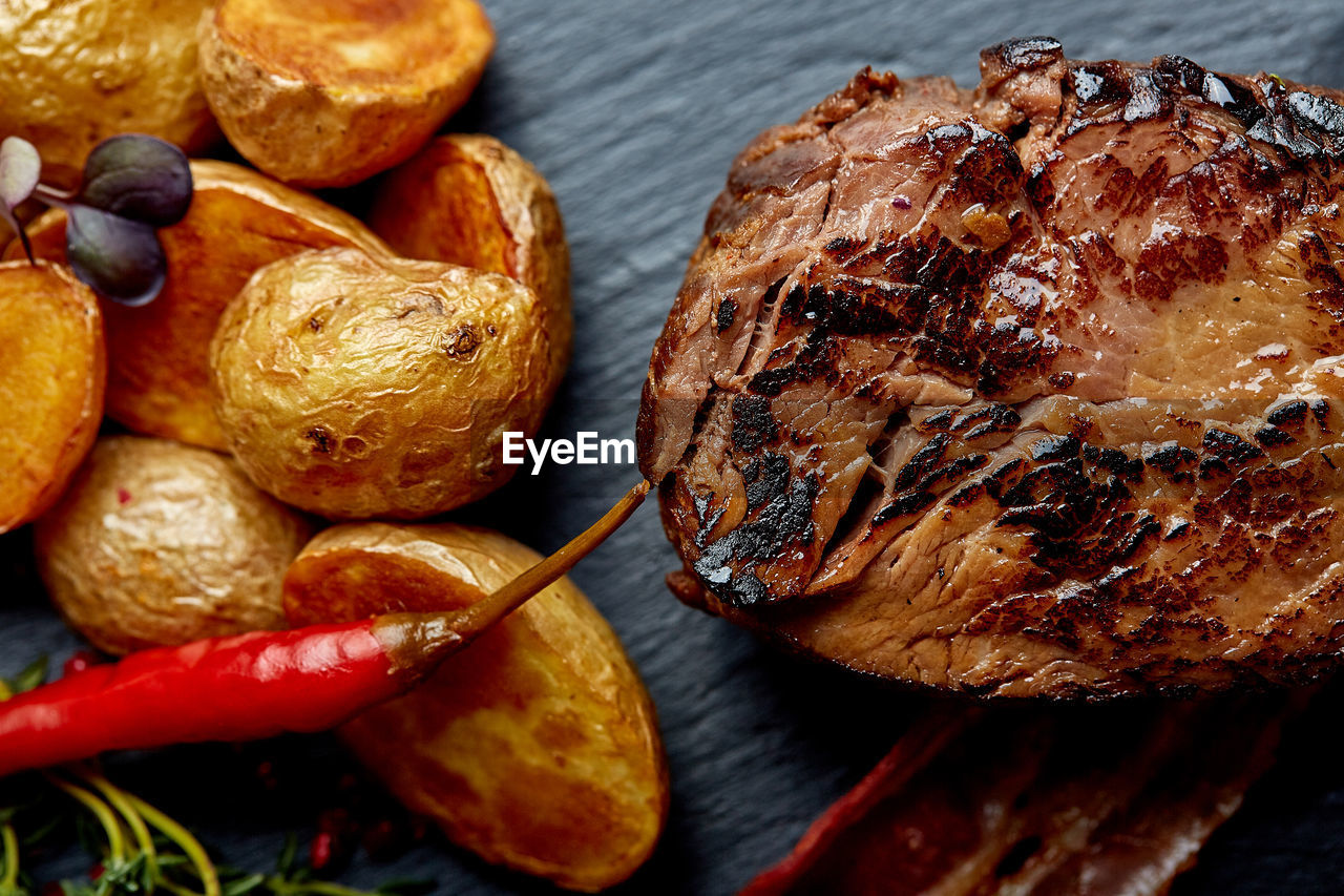 HIGH ANGLE VIEW OF MEAT ON BARBECUE TABLE