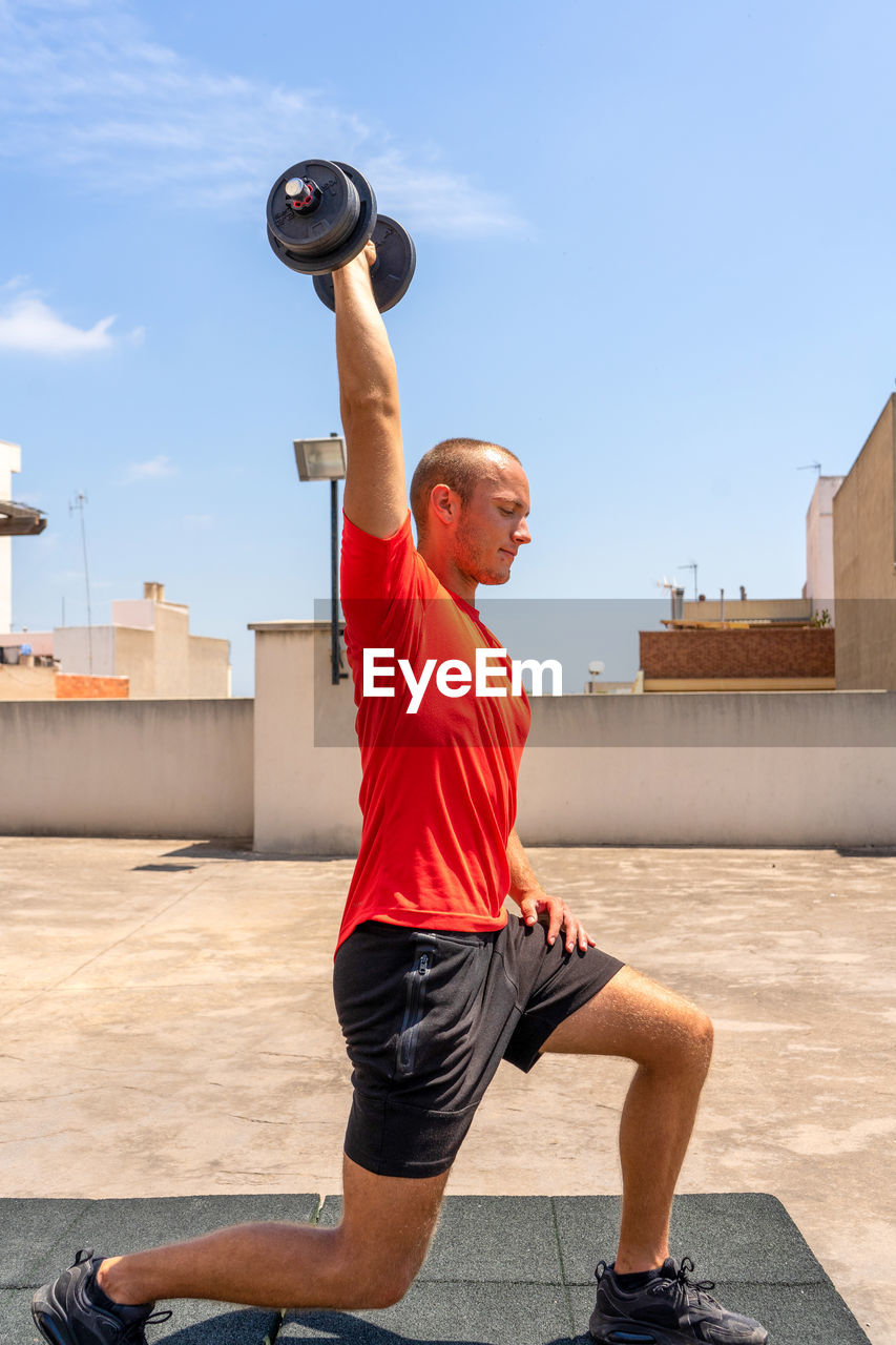 Side view of man exercising on terrace