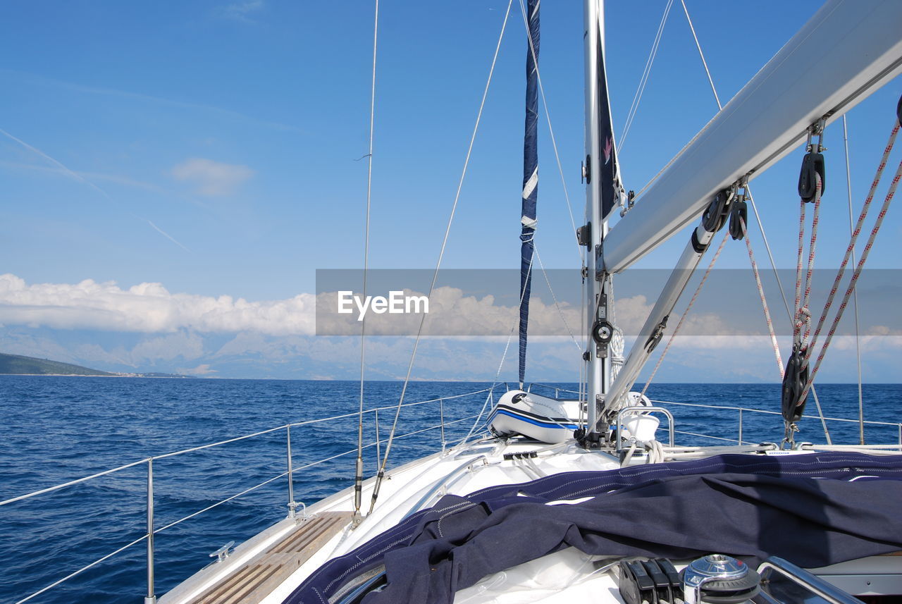 Sailboat sailing on sea against sky