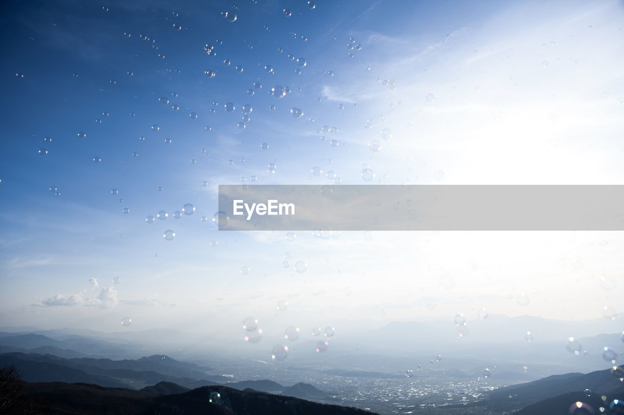 WATER DROPS ON SILHOUETTE MOUNTAIN AGAINST SKY