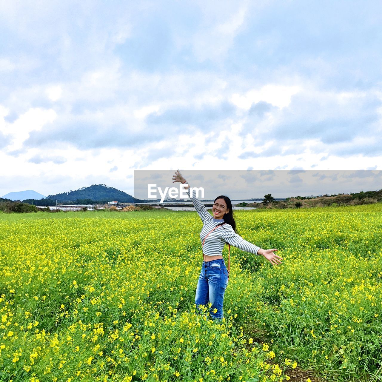 Portrait of smiling woman standing on field