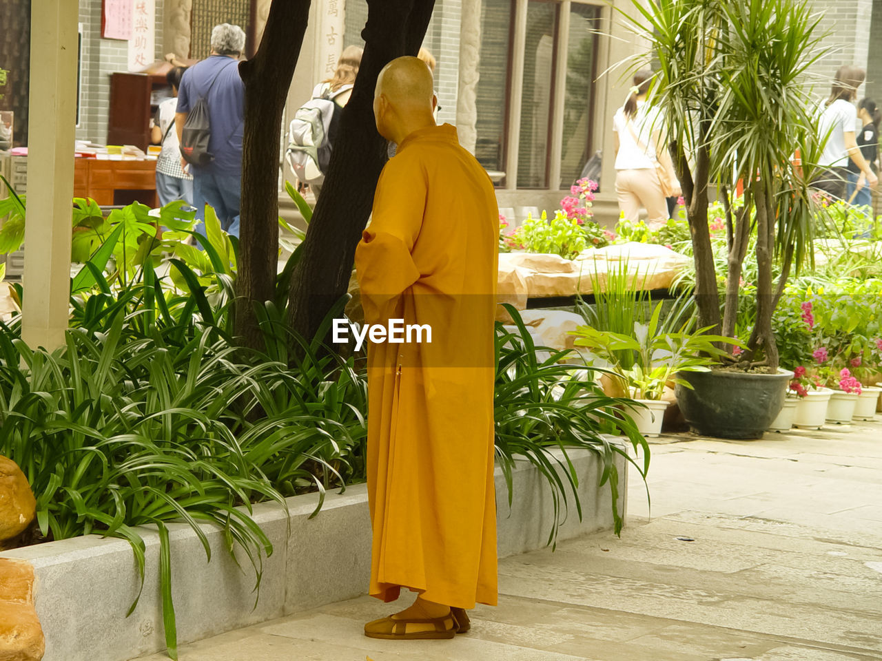 REAR VIEW OF MAN AND WOMAN WALKING BY STATUE