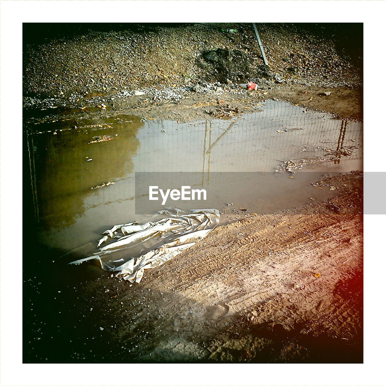 High angle view of puddle on dirt road