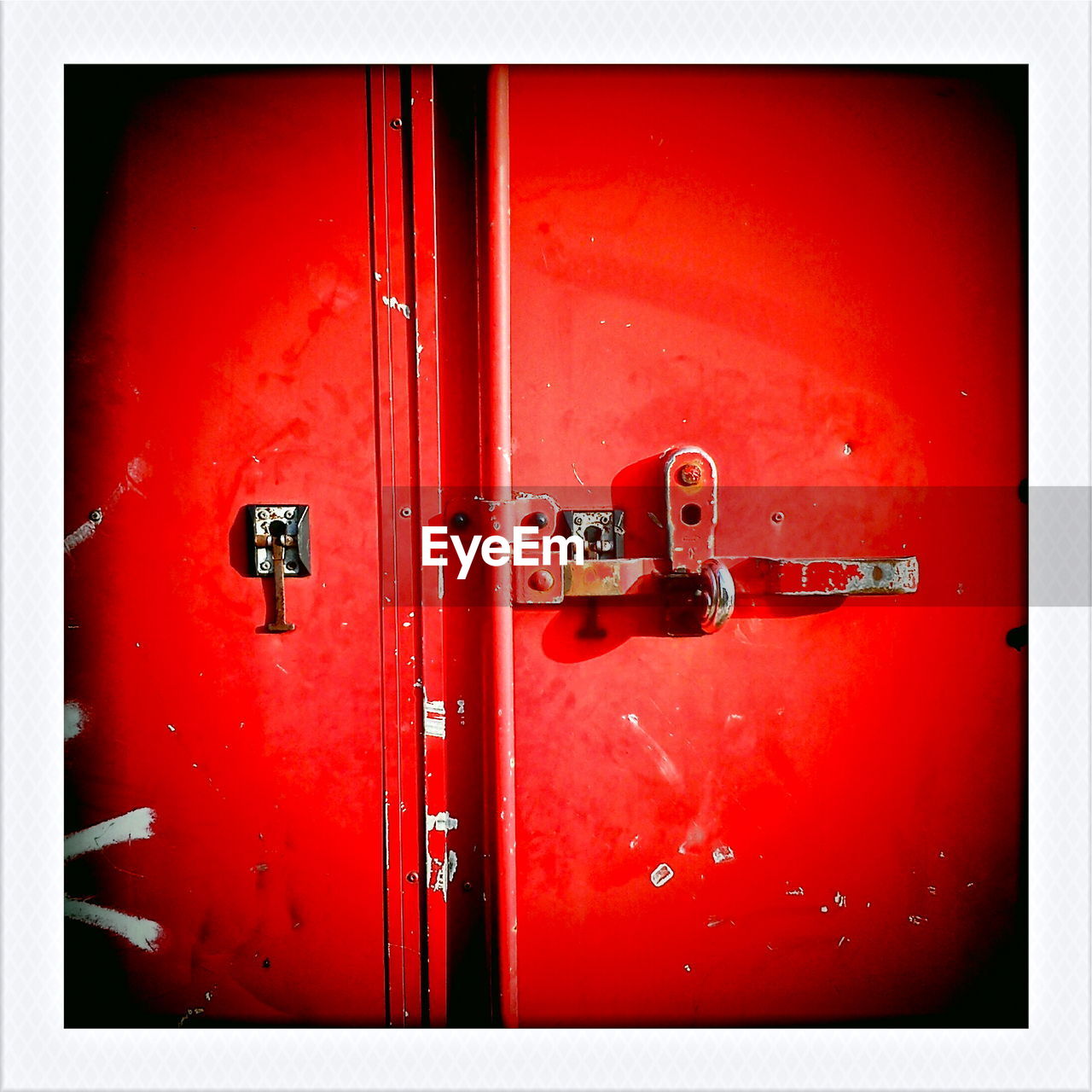Cropped image of red closed metal door with padlock