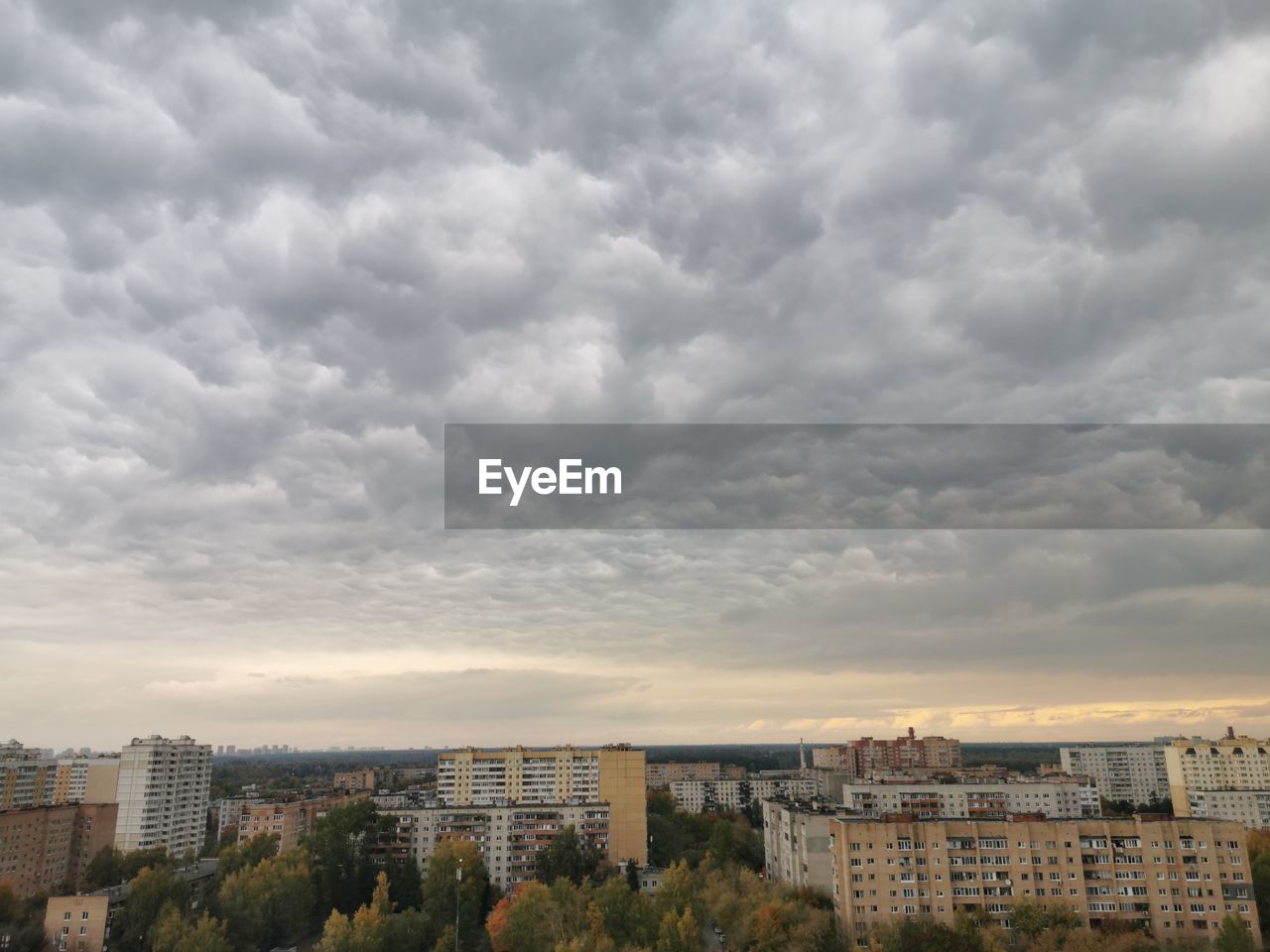 High angle view of buildings in city against storm clouds