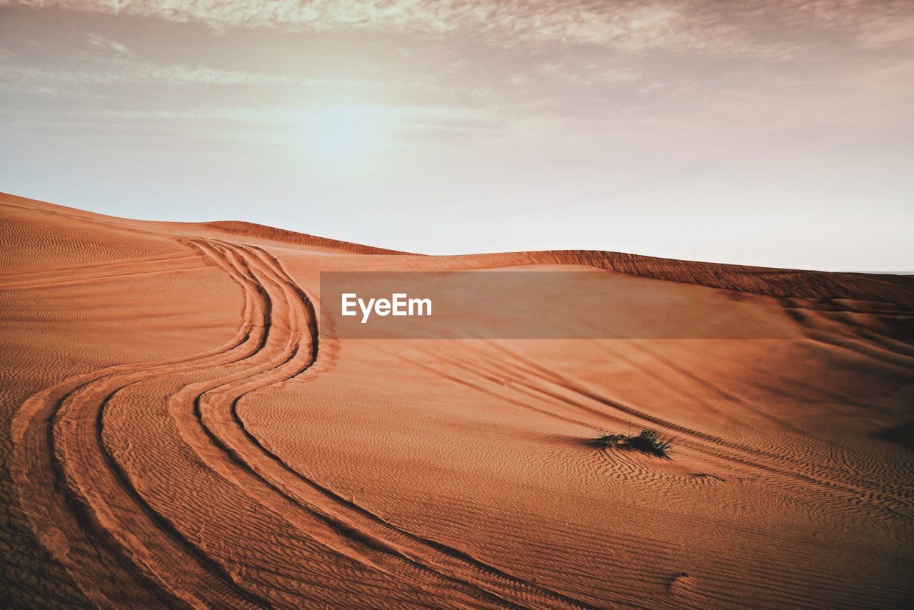 Scenic view of sand dune against sky