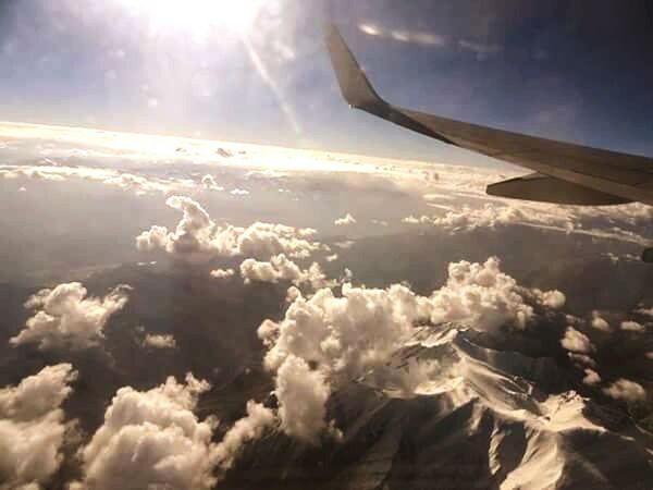 CROPPED IMAGE OF AIRPLANE WING OVER LANDSCAPE