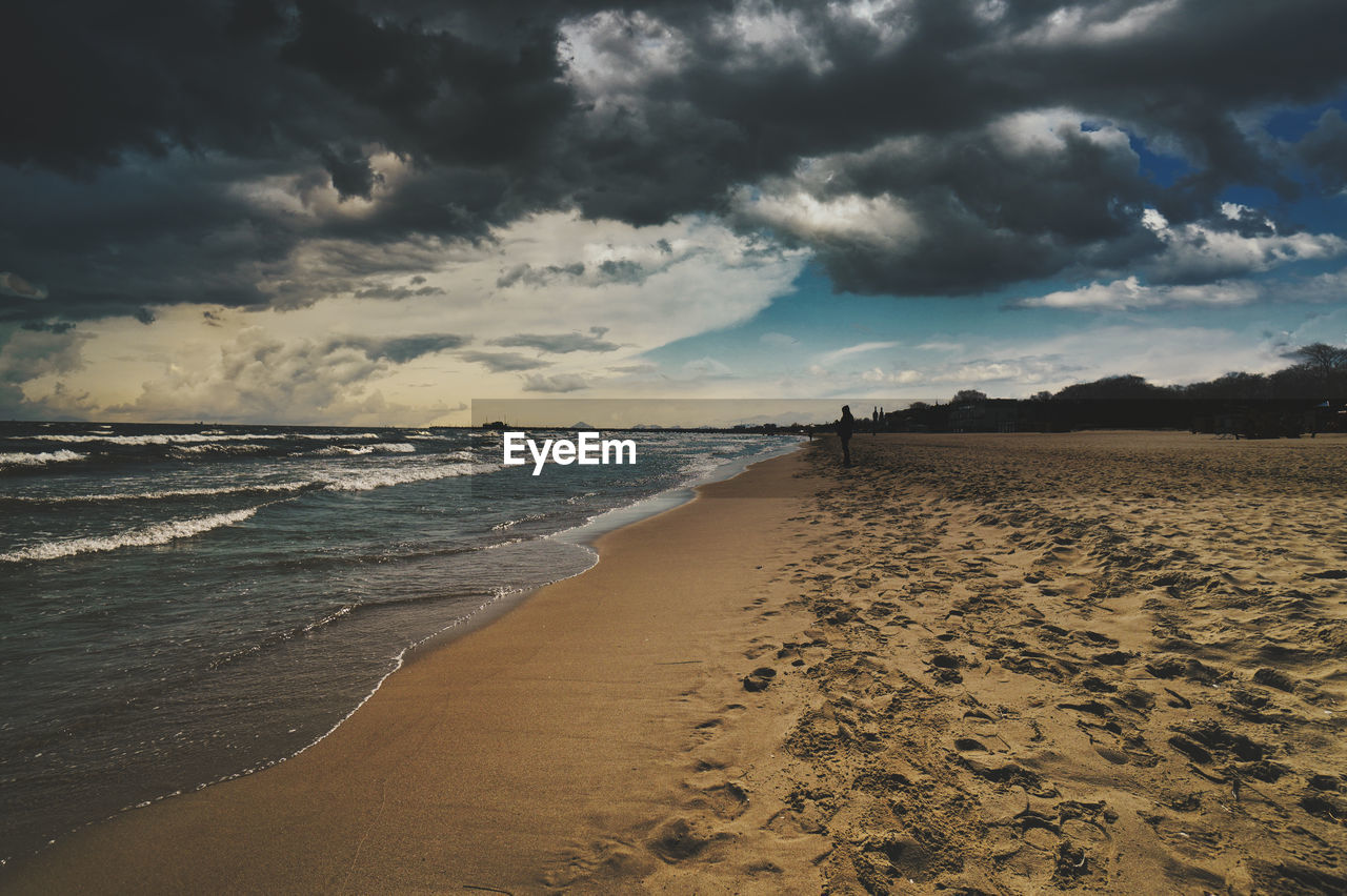 Scenic view of beach against sky during storm