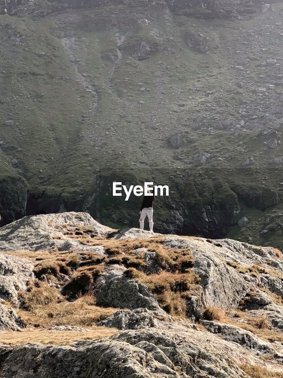 Full length of man standing on rock against mountain