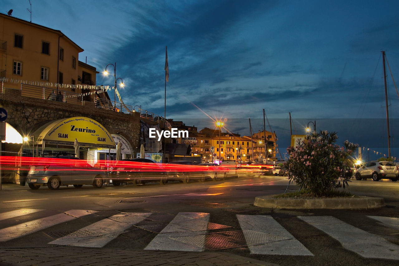 LIGHT TRAILS ON STREET AT NIGHT