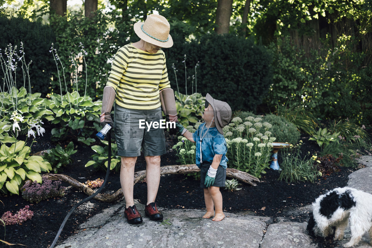 Grandmother with grandson standing in garden
