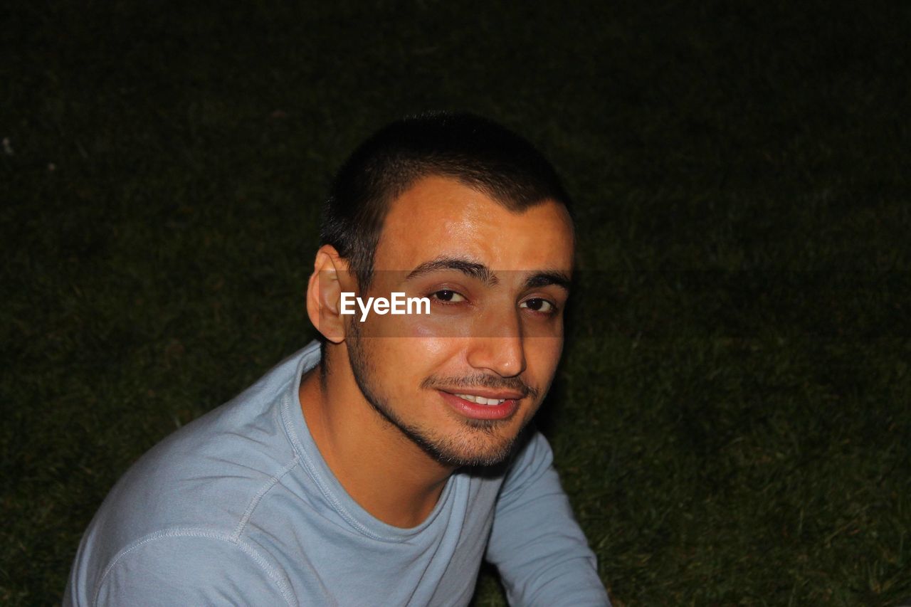 portrait, one person, looking at camera, smiling, men, young adult, person, grass, adult, headshot, happiness, casual clothing, emotion, lifestyles, front view, human face, copy space, fun, cheerful, leisure activity, beard, nature, high angle view, night, black hair, relaxation, plant, teenager, looking, facial hair, outdoors