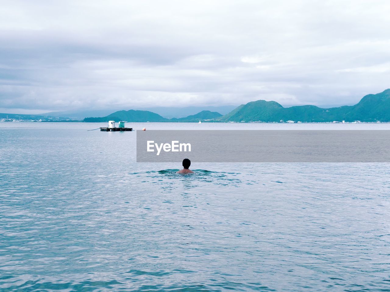 MAN ON SAILBOAT IN SEA AGAINST SKY