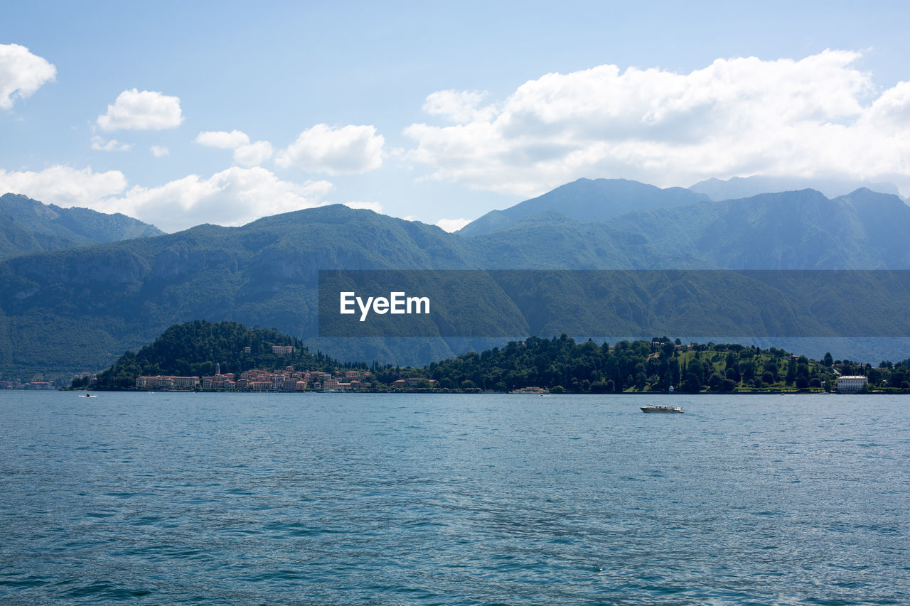 Scenic view of lake by mountains against sky