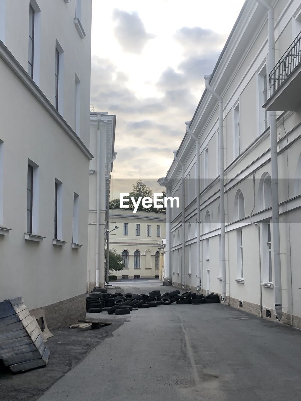 Empty road amidst buildings against sky