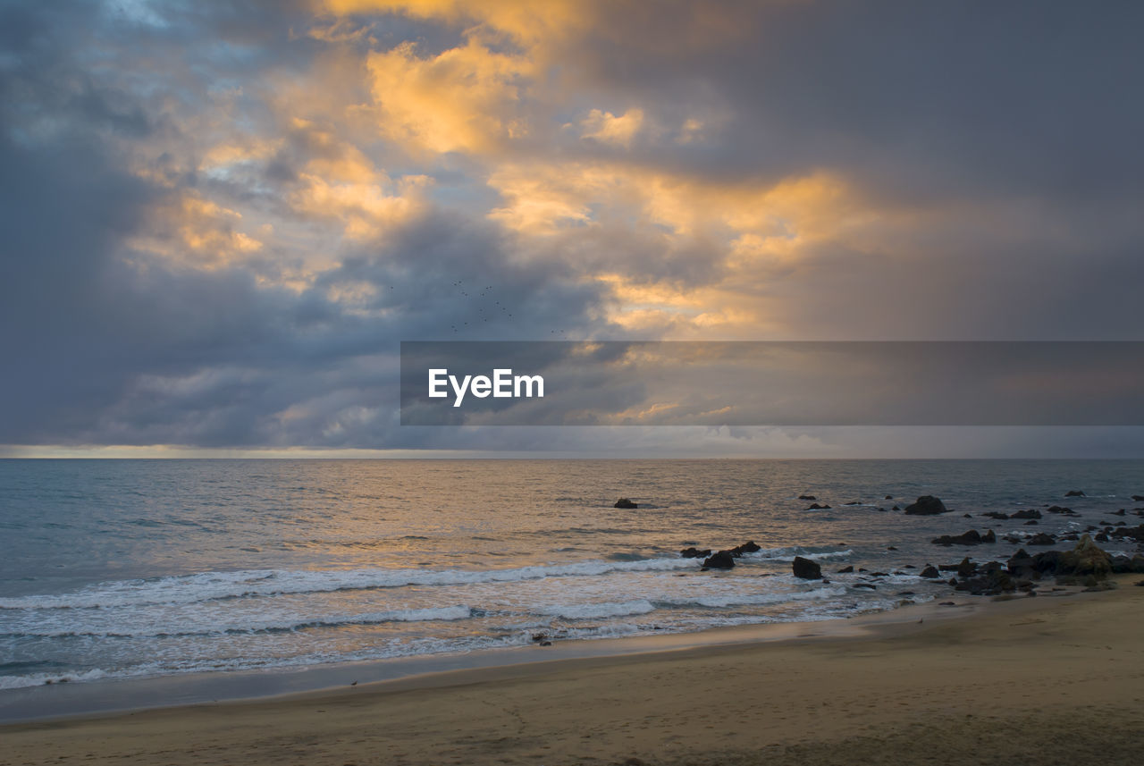 SCENIC VIEW OF BEACH DURING SUNSET