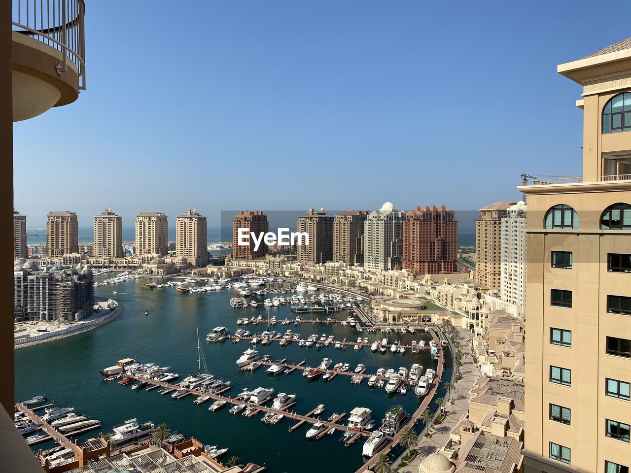 Aerial view of pearl qatar city buildings against blue sky