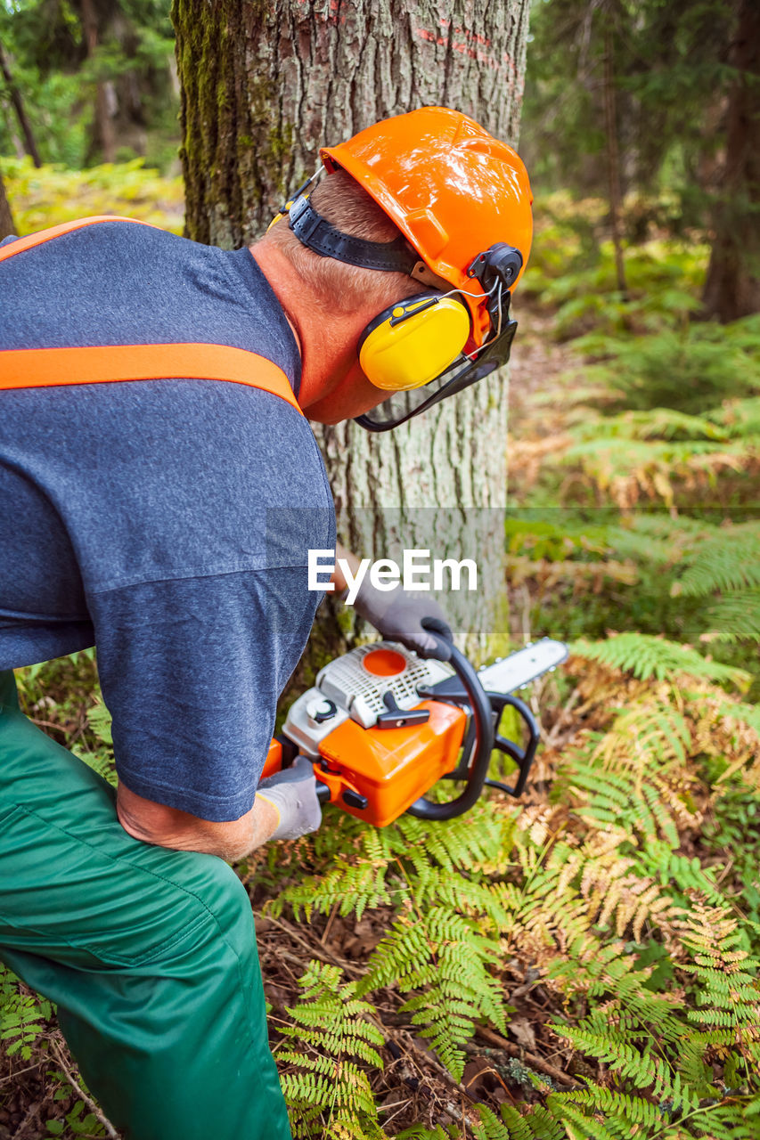 Midsection of man working in forest