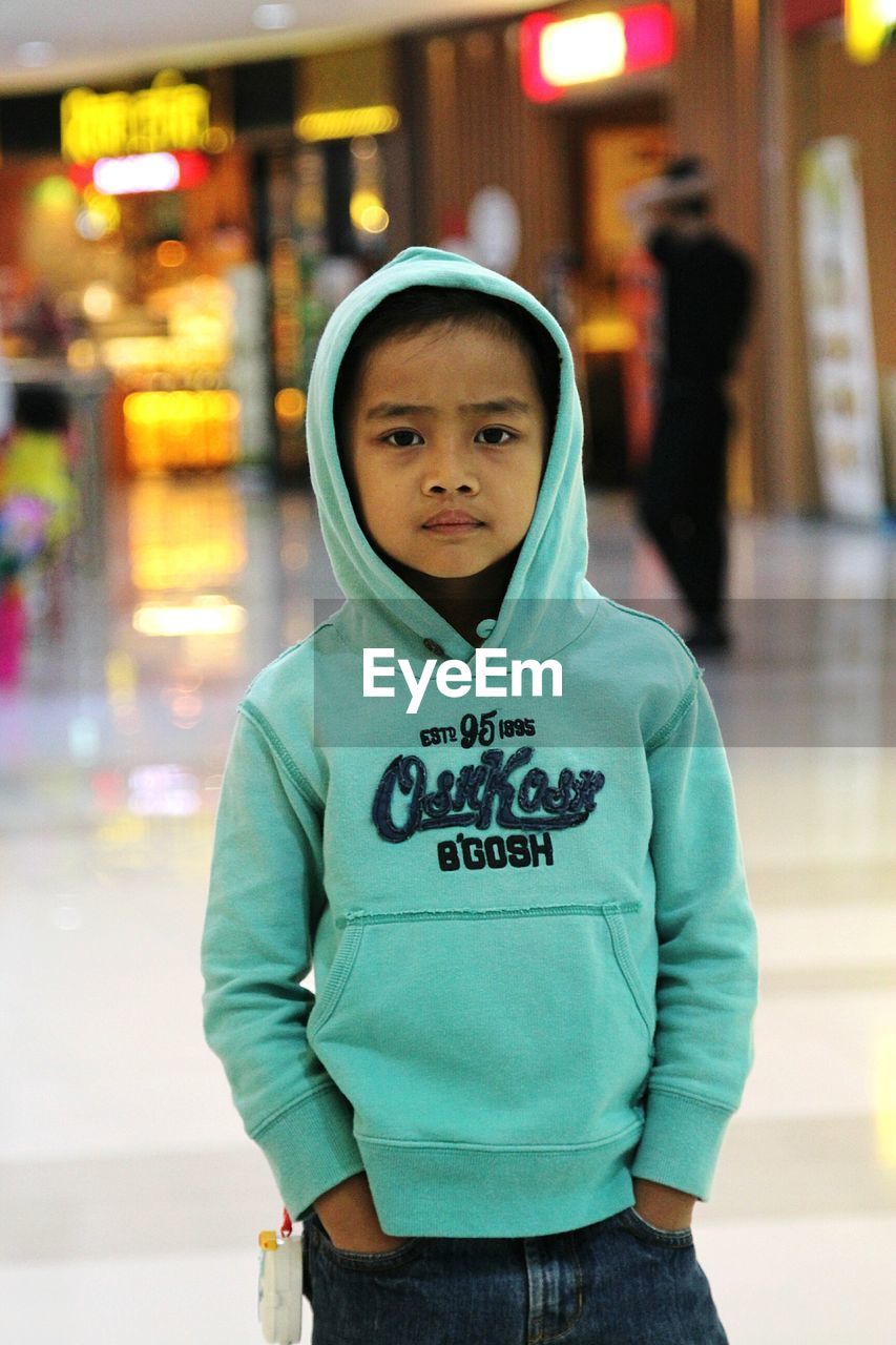 Portrait of boy standing at shopping mall